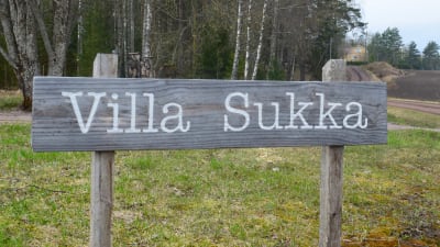En skylt gjord av gammal drivved där det står Villa Sukka.