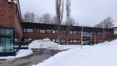 En röd tegelbyggnad med många fönster. Här finns biblioteket och kommunhuset i Ingå.
