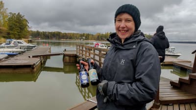 En kvinna håller upp två ölfaskor.