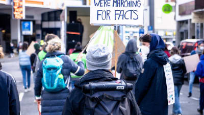 En demonstration mot falska nyheter där någon bär på en skylt där det står: Can´t believe we are marching for facts.