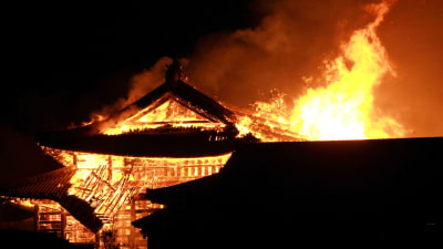 Eldslågor slår upp från det brinnande slottet Shuri på Okinawa