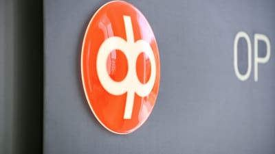 Op:s orange logga på en grå vägg.