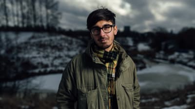adrian perera står med en vintrig bakrund bakom sig