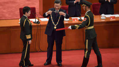 Kinas president Xi Jinping belönar en kinesisk general som lett ett vaccinforskningsteam. 8.9.2020