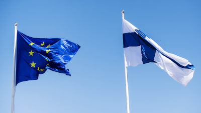 EU:s flagga till vänster, Finlands flagga till höger.