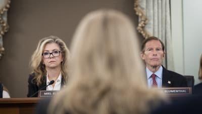 I förgrunden en ljushårig kvinnas huvud bakifrån och i bakgrunden till vänster en kvinna och till höger en man som båda tittar mot den första kvinnan. Frances Haugen hörs i senaten om Facebook.