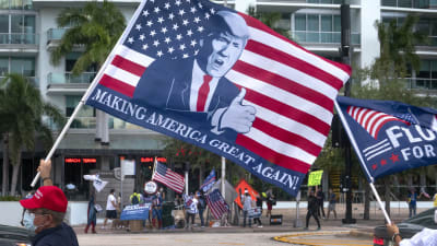Demonstrant med Trump-flagga utanför tv-huset i Miami där Trump svarade på frågor som en del i kampanjen.