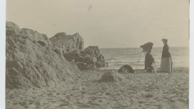 Kvinna fotograferar på stranden på Île Saint-Honorat i Cannes, sekelskiftet 1800-1900.