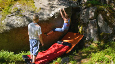 Carolina Mikander hänger på baksidan av stenen och värmer upp. 