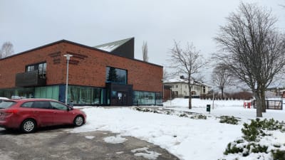En byggnad i mörkt rött tegel med mycket fönster. Där finns Ingå bibliotek och Ingå kommunhus.