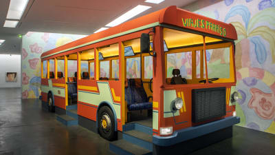 En orange buss inne i ett museum.