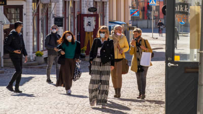 Personer promenerar med munskydd på Mellangatan i Borgå.