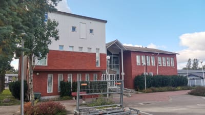 En byggnad i rött och vitt tegel som är Sjundeå kommunhus.