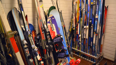Skidor och snowboards staplade upp längs med väggarna. 