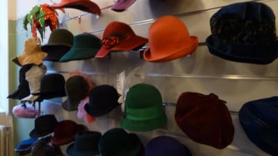 Färggranna damhattar på en ställning i hattaffären.