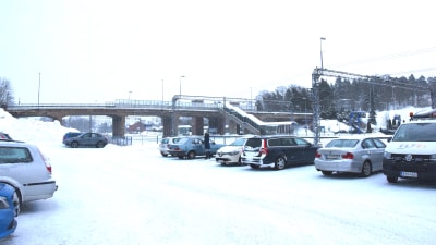 Bilar är parkerade nedanför järnvägsbron i Karis.