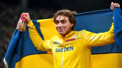 Armand Duplantis med svenska flaggan bakom ryggen.