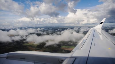 Vy från ett flygplan. Moln och terräng syns på bilden som tagits i Finland i september 2020.
