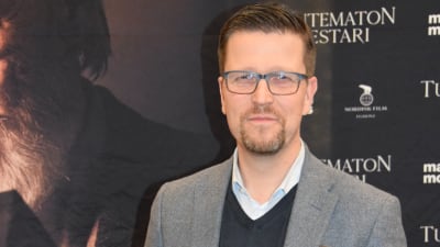 Klaus Härö poserar framför planschen till Okänd mästare.