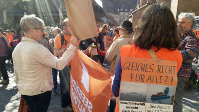 Personer som demonstrerar, de har tyska texter på plakat.