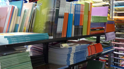 Många skolböcker (gymnasieböcker) på hyllor i en bokhandel.