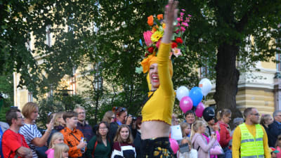Kvinna i färgglada kläder dansar på gatan.