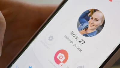 En telefonskärm där en ung dam, "Iida, 27" presenteras med foto på en nätrdejtingsida.