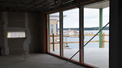 Foto taget i en bostad som hålls på att byggas. Genom glasdörrarna ser man stadsfjärden i Ekenäs och restaurang Knipan.