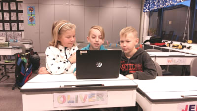 Emilia Eriksson, Oliver Helenius och Lasse Rantanen sitter vid en dator i Kirjala skola.