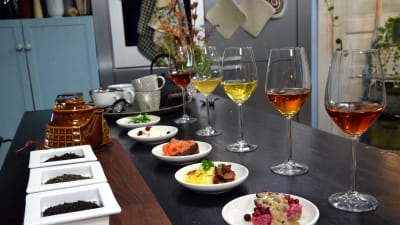 vinglas med olika teér och tallrikar med olika maträtter på ett bord
