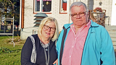 Sirpa och John Mannil framför sitt hus i Vörå