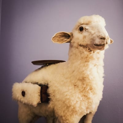Ett får med byrålådor som kommer ut ur dess sida samt en bricka på ryggen. Av Salvador Dalí.