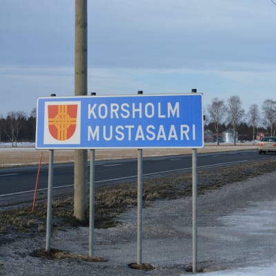 Skylt med texten Korsholm i förgrunden och skylt med texten Vasa i bakgrunden.