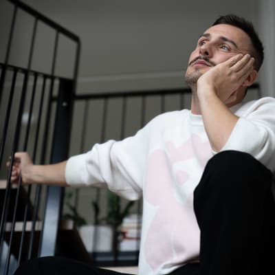 Joonas Pesonen istuu portailla mietteliäänä.