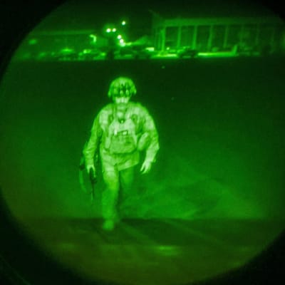 Den sista amerikanska soldaten i Afghanistan generalmajor Chris Dunahue stiger in i ett transportplan. Det är natt och bilden är tagen genom en mörkerlins.