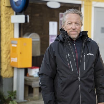 En person står utanför bybutiken.