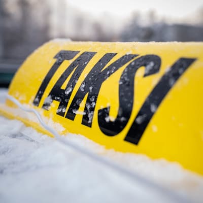 Lähikuva anonyymin itsenäisen taksiyrittäjän taksikyltistä auton katolla, 16.12.2022.