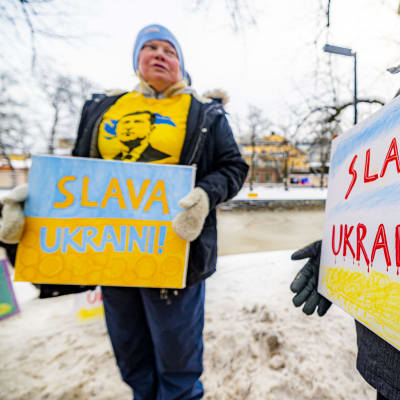 Kvinna håller i en skylt där det står Slava Ukraini