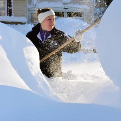 Kvinna kämpar med snöröjningen i Buffalo.
