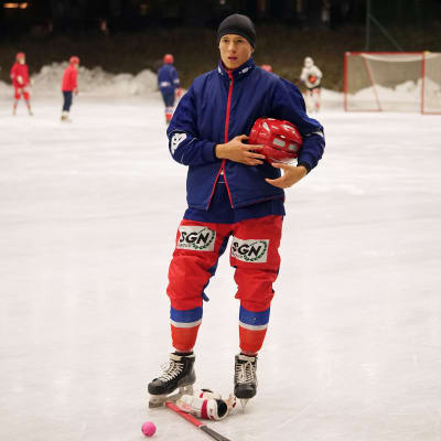 Kevin Larsson håller i sin hjälm på isen.