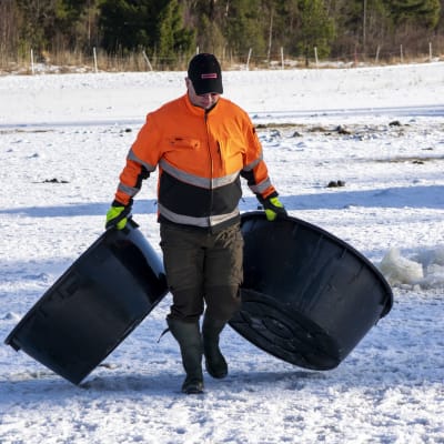 Jordbrukare släpar på två vattendunkar. 