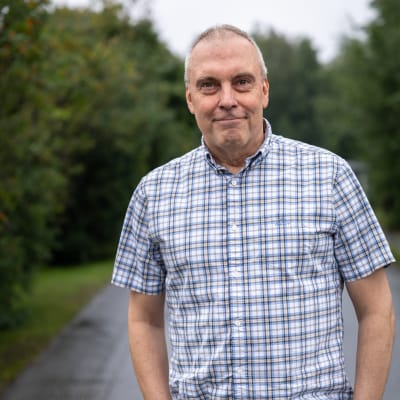 Porträttfoto av man i somrig utemiljö