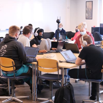 Ungdomar sitter i ett klassrum. Alla har en laptop framför sig.