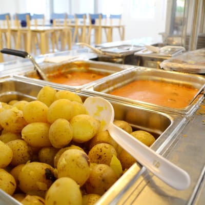 Potatis och köttbullar väntar på hungriga elever i skolmatsal.