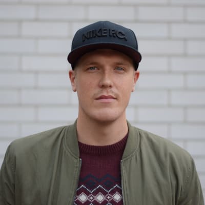 Man i svart keps och grön jacka.