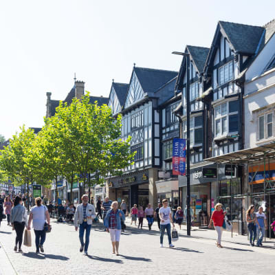 Gågatan i centrum av Wigan en solig dag. I stadens centrum finns många låga historiska hus. 