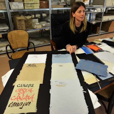 Danila Versini visar exempel på papper från olika typer av återvunnet material. Dessa använder modeföretag till etiketter, märken och paketpapper.