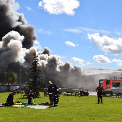 brandmän framför brinnande affärshus