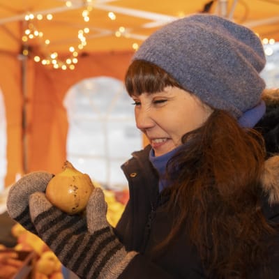 Koronan sairastanut Johanna Pekari Kauppatorilla torikojussa haistelee sipulia