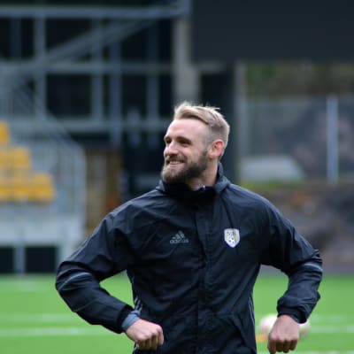 Richie Dorman stretchar benen på SJK:s träningar.